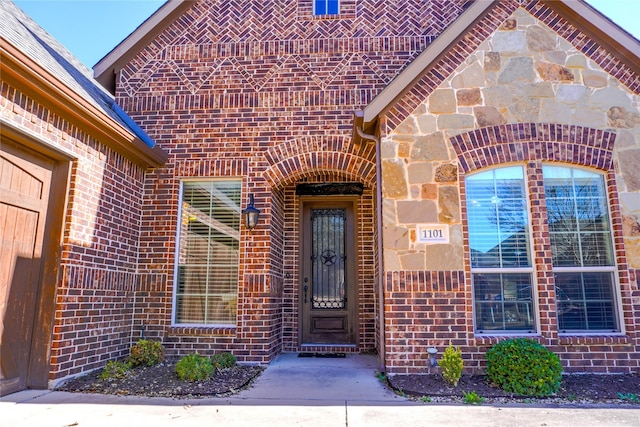 view of exterior entry with brick siding