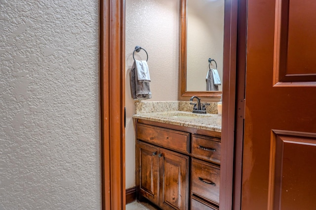 bathroom featuring vanity and a textured wall