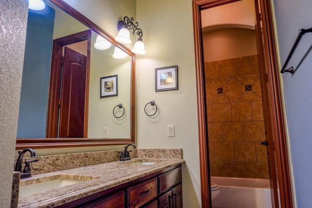 full bathroom featuring double vanity, toilet,  shower combination, and a sink