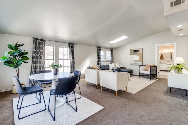 carpeted dining area with vaulted ceiling and visible vents