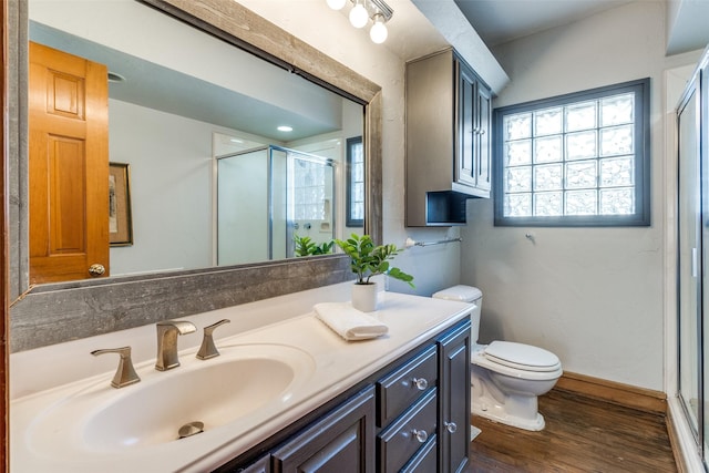 bathroom featuring a shower stall, vanity, toilet, and wood finished floors