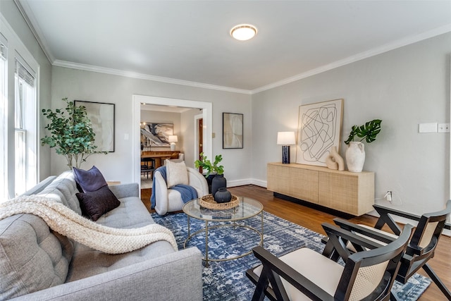 living area with crown molding, wood finished floors, and baseboards