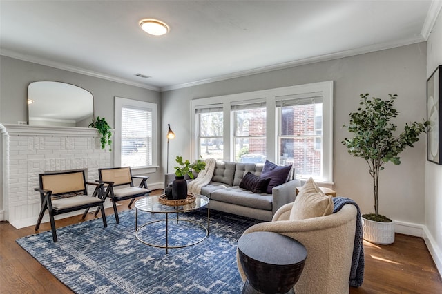 living room with visible vents, dark wood-style floors, crown molding, baseboards, and a brick fireplace