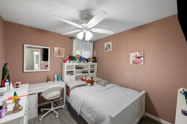 bedroom featuring ceiling fan, baseboards, and wood finished floors