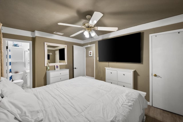 bedroom featuring visible vents, ensuite bath, ceiling fan, and wood finished floors