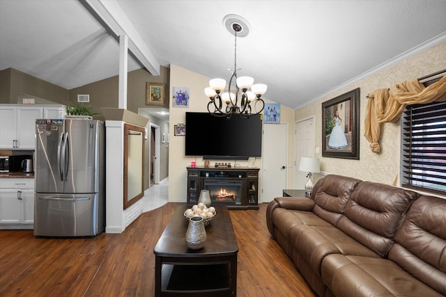 living room with dark wood finished floors, an inviting chandelier, vaulted ceiling with beams, and a lit fireplace