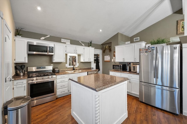 kitchen with a sink, appliances with stainless steel finishes, dark wood-style flooring, and white cabinetry