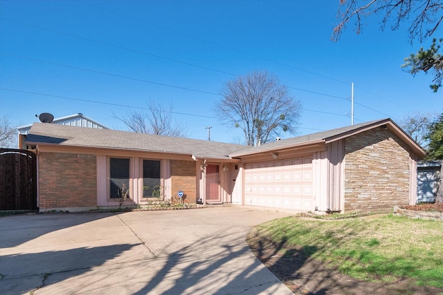 view of front of property with brick siding, a front yard, an attached garage, and driveway