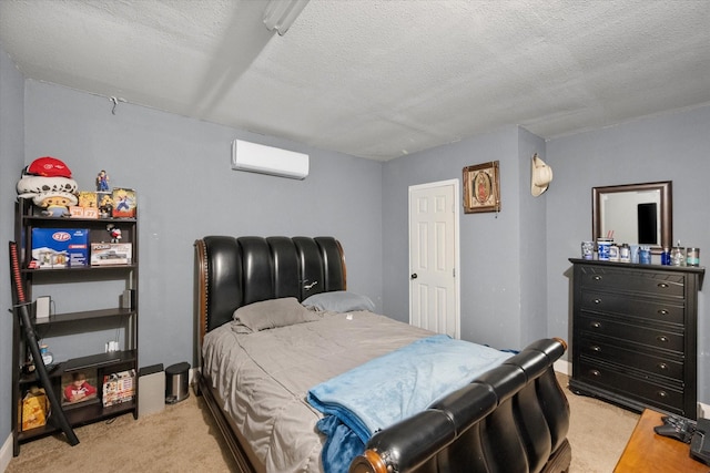 bedroom with a textured ceiling, light colored carpet, and a wall unit AC