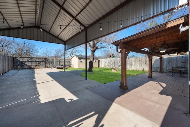 view of patio / terrace with a storage shed, an outbuilding, a fenced backyard, and ceiling fan