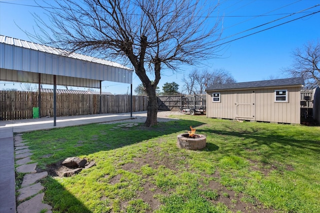 view of yard featuring a fire pit, a fenced backyard, a storage shed, and an outdoor structure