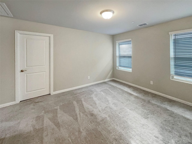 empty room with visible vents, carpet flooring, and baseboards