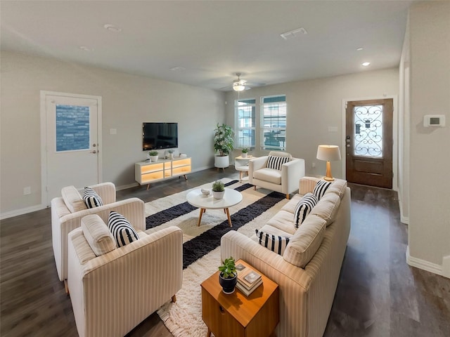 living area featuring wood finished floors, visible vents, and baseboards