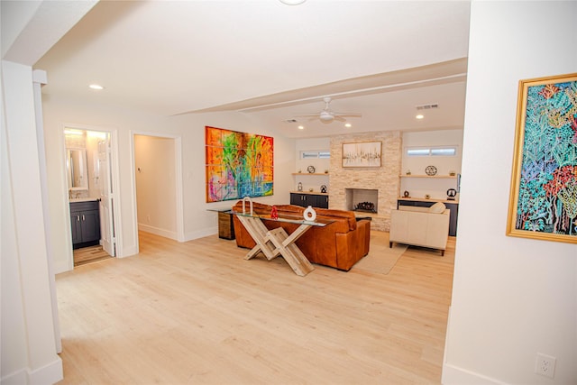 office area featuring visible vents, a large fireplace, light wood-type flooring, recessed lighting, and a ceiling fan