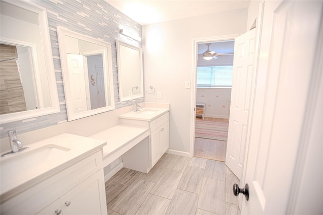 full bath featuring double vanity, baseboards, and a sink