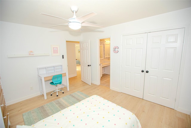 bedroom featuring a closet, ensuite bathroom, baseboards, and wood finished floors