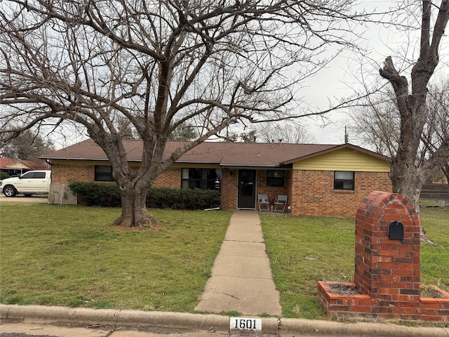 ranch-style home featuring brick siding and a front yard