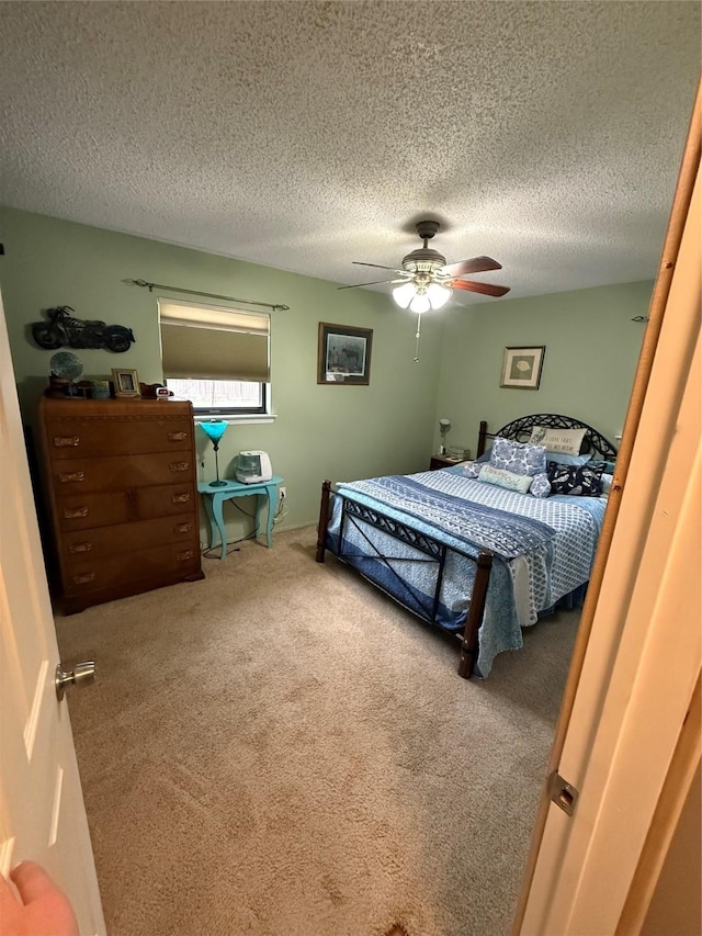 bedroom featuring a textured ceiling, a ceiling fan, and carpet floors