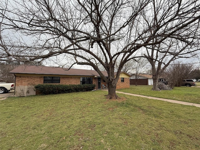 view of front of home with brick siding and a front yard