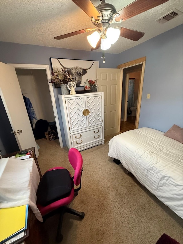 bedroom featuring ceiling fan, carpet flooring, visible vents, and a textured ceiling