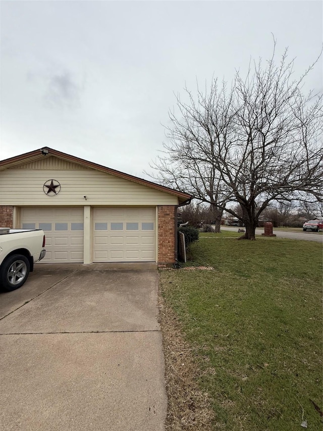 exterior space featuring brick siding, a yard, driveway, and a garage