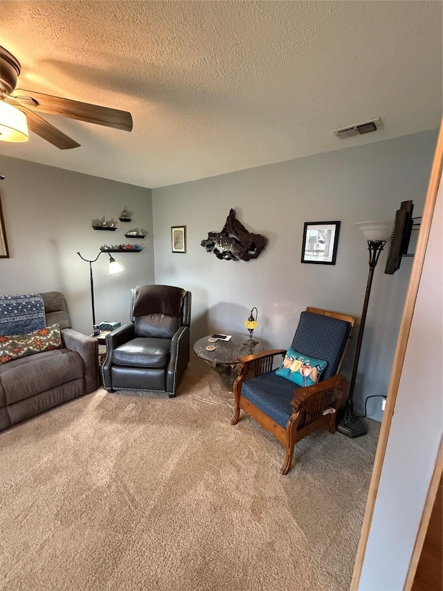 interior space with carpet, a ceiling fan, visible vents, and a textured ceiling