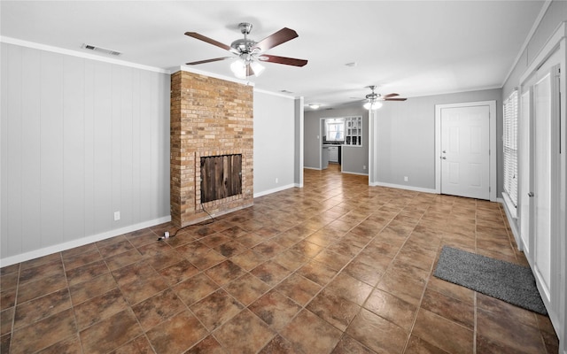 unfurnished living room featuring visible vents, ornamental molding, a ceiling fan, baseboards, and a brick fireplace