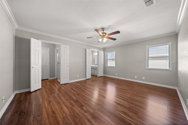 unfurnished bedroom featuring visible vents, crown molding, dark wood-type flooring, baseboards, and a ceiling fan