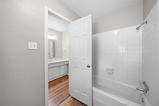 bathroom with vanity, wood finished floors, and tub / shower combination