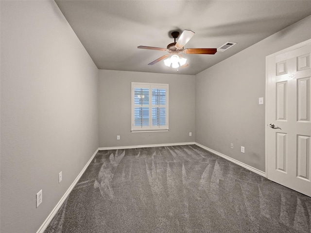 spare room featuring visible vents, baseboards, ceiling fan, and dark colored carpet