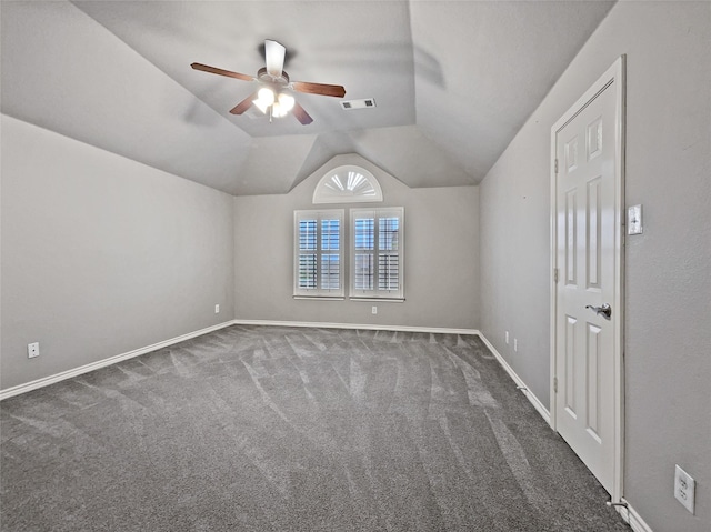 interior space featuring visible vents, baseboards, carpet, lofted ceiling, and a ceiling fan