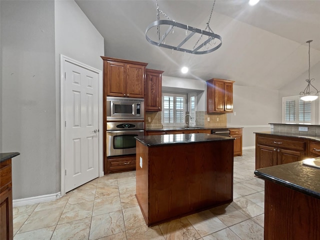 kitchen with lofted ceiling, a sink, stainless steel appliances, backsplash, and a center island