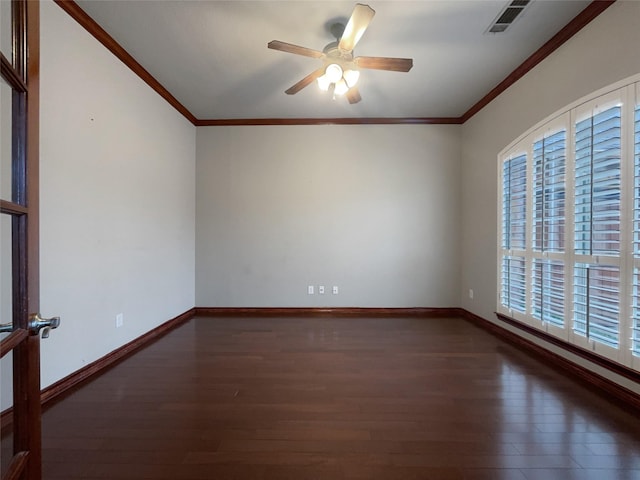 empty room with visible vents, crown molding, and wood finished floors