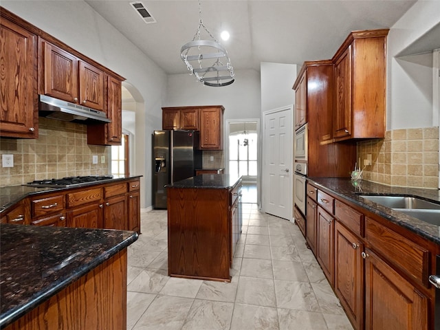 kitchen with under cabinet range hood, visible vents, marble finish floor, and appliances with stainless steel finishes