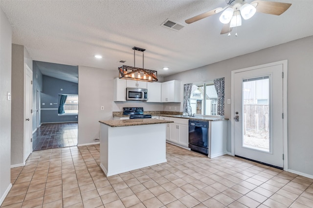 kitchen featuring stainless steel microwave, visible vents, a center island, black dishwasher, and range