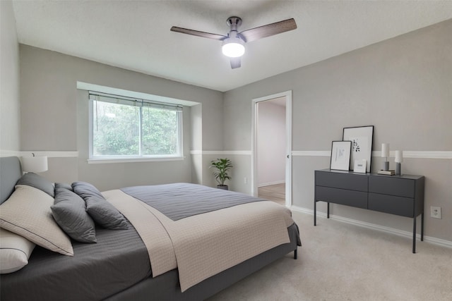 bedroom with baseboards, light carpet, and a ceiling fan