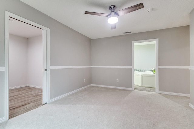 empty room with visible vents, baseboards, carpet, and a ceiling fan