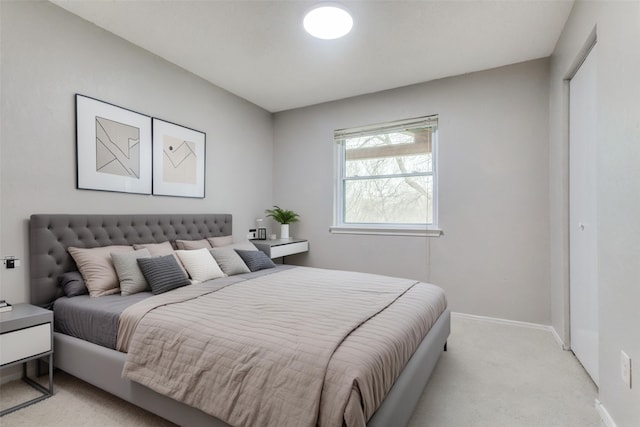 bedroom featuring light colored carpet and baseboards