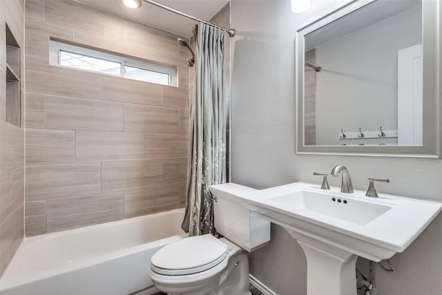 full bath featuring toilet, shower / bathtub combination with curtain, and a sink