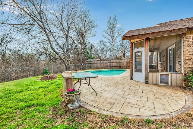 view of swimming pool featuring a fenced backyard, a fenced in pool, a yard, and a patio