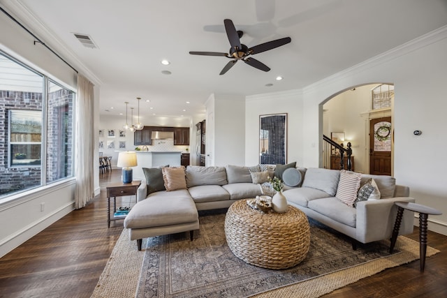 living room with visible vents, arched walkways, dark wood-type flooring, and ornamental molding