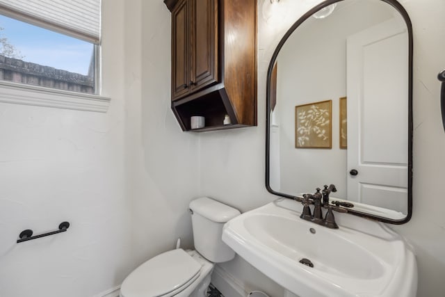 half bath with toilet and a sink