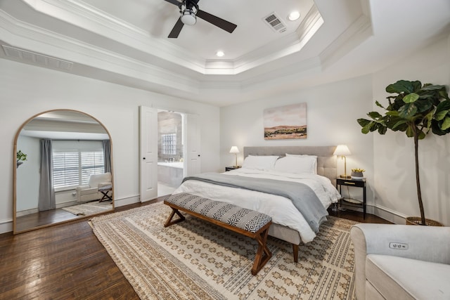 bedroom featuring visible vents, crown molding, a tray ceiling, and hardwood / wood-style floors