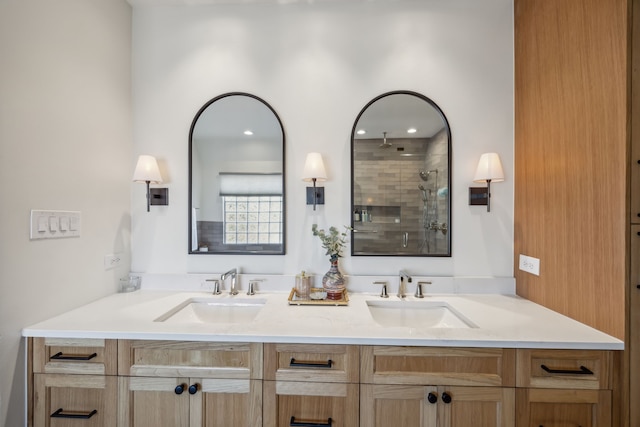 bathroom with double vanity, a stall shower, and a sink