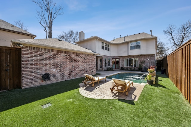 back of property featuring a lawn, a fenced backyard, an outdoor pool, brick siding, and a patio area