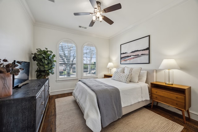 bedroom with dark wood-style floors, visible vents, crown molding, and baseboards