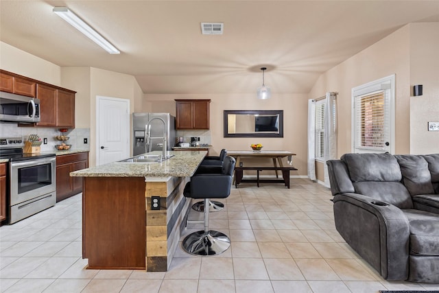 kitchen featuring visible vents, a sink, open floor plan, stainless steel appliances, and light tile patterned floors