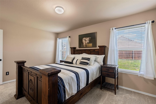 bedroom featuring light carpet and baseboards