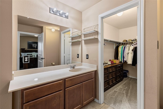 bathroom featuring a spacious closet, tile patterned flooring, and vanity