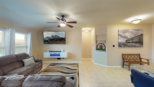 living area featuring light tile patterned floors, baseboards, ceiling fan, and vaulted ceiling